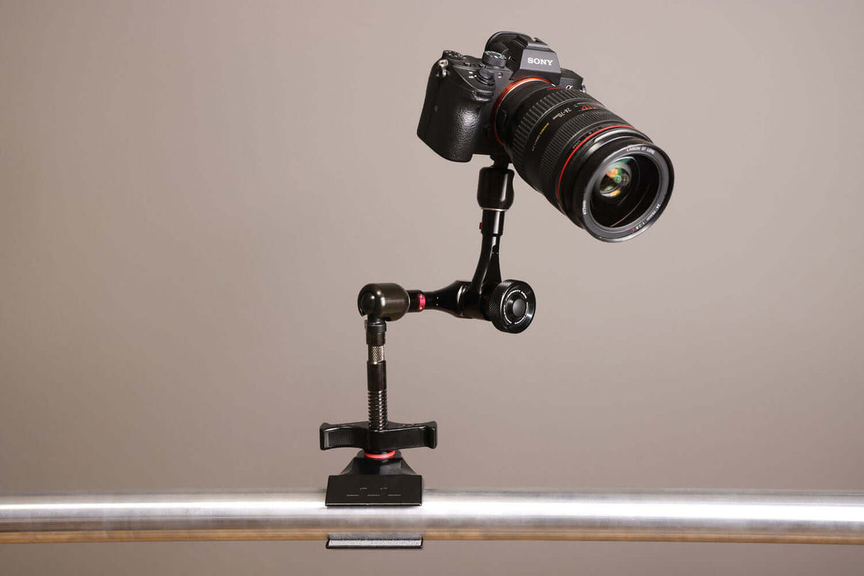 Camera mounted on a Black Hyper-Chrome™ Matthellini2 Clamp against a gray background, showcasing enhanced stability and support.