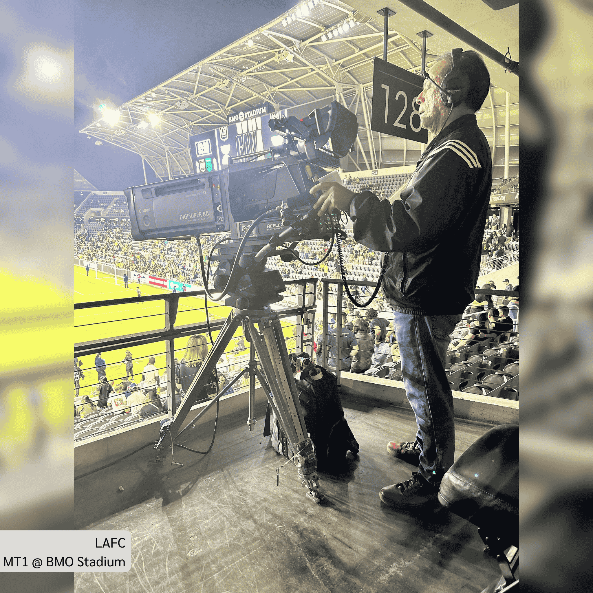 Cameraman operating a television camera at LAFC match in BMO Stadium, capturing live soccer action.