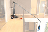 Middle MAX Menace Arm reaching over balcony for support, showcasing its extendable boom stand in a modern studio environment.