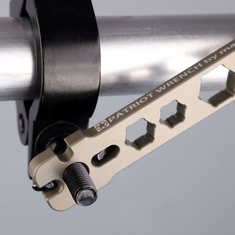 Close-up of the Patriot Wrench adjusting a pipe clamp, showcasing its versatile design and cutouts for professionals.