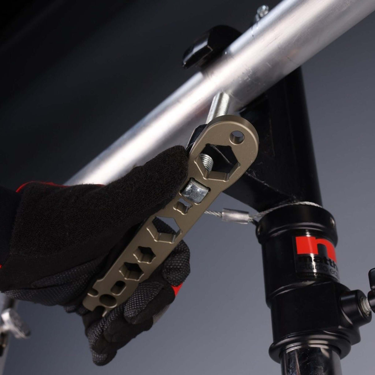 A person using the Patriot Wrench with a pipe clamp, showcasing its versatility in professional rigging applications.