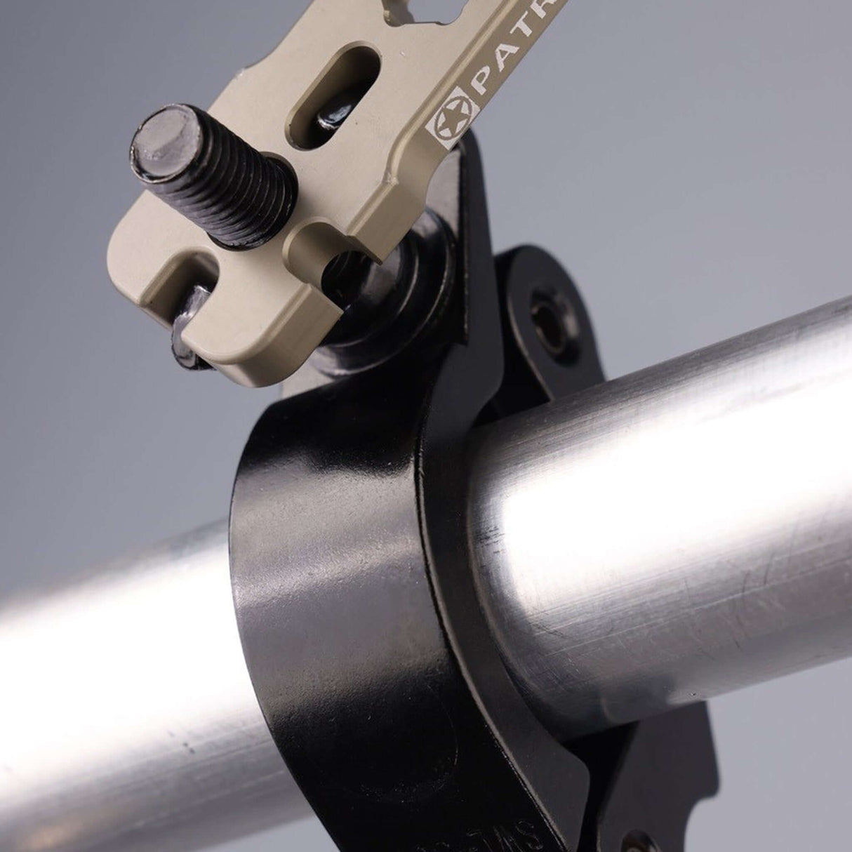 Close-up of the Patriot Wrench adjusting a clamp on a metal pipe, showcasing its professional rigging design.