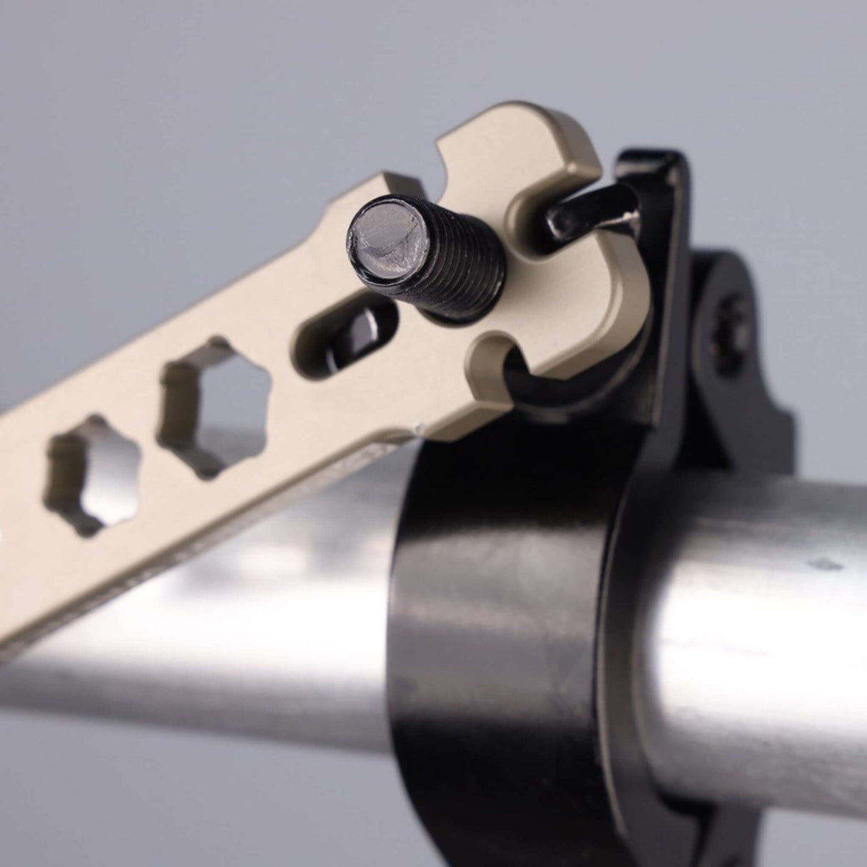 Close-up of the Patriot Wrench adjusting a pipe clamp with hex nut cutouts for professional rigging applications.