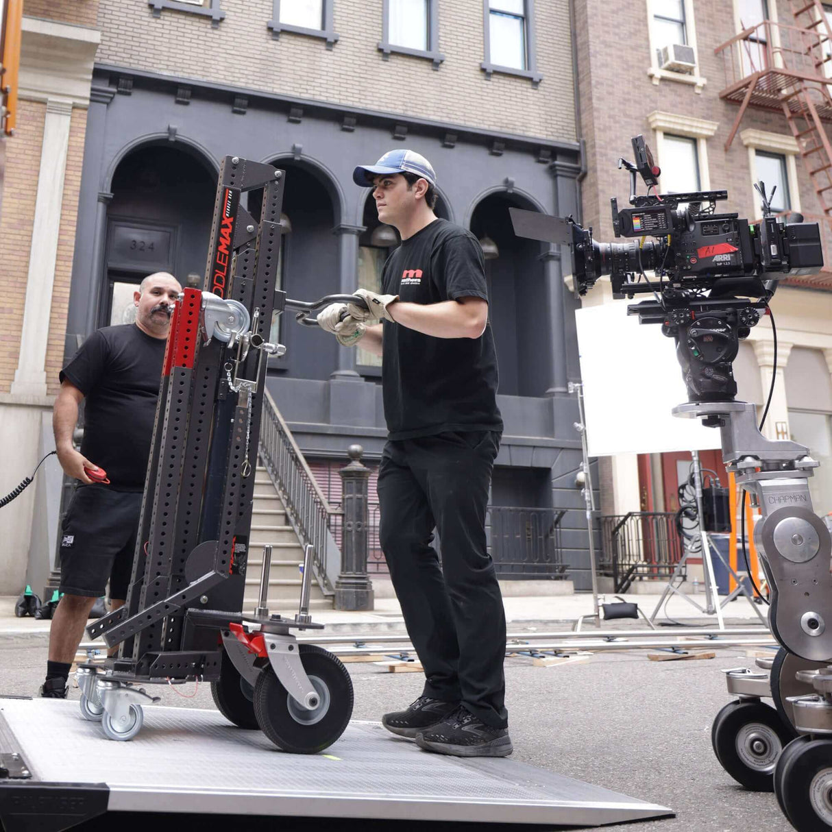 Technician adjusting Middle MAX Menace Arm stand on a film set