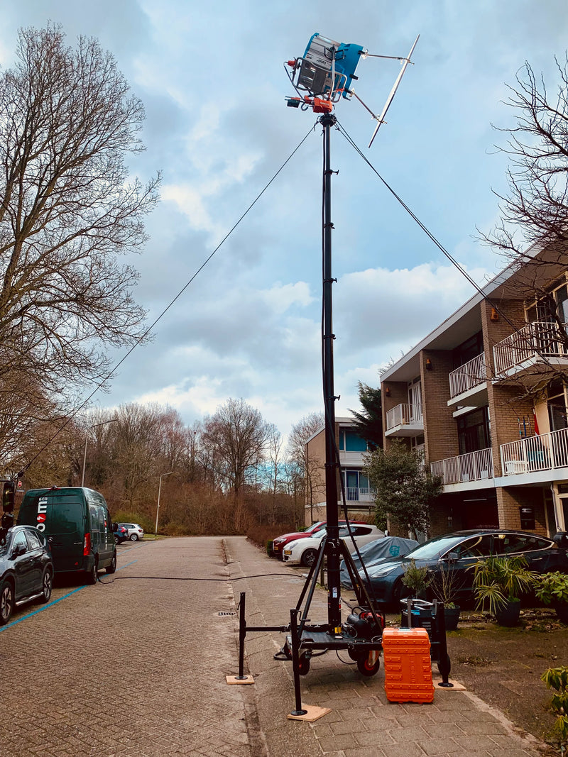 Mobile antenna mast set up on a residential street, used for telecommunications in an urban area.